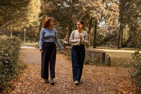 Twee vrouwen buiten wandelend in gesprek